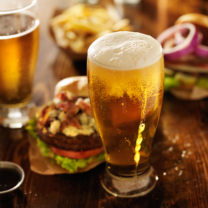 Lagar Beer in a glass next to a hamburger